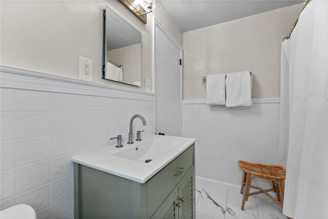 4030 Dalewood St, Brentwood, PA 15227 - bathroom with tile walls, marble finish flooring, a wainscoted wall, and vanity