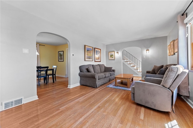 4030 Dalewood St, Brentwood, PA 15227 - living area with arched walkways, light wood-style floors, baseboards, and stairs