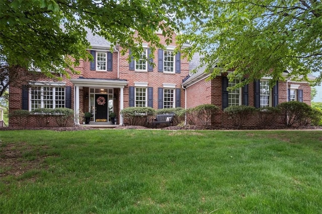 view of front facade with a front lawn and brick siding
