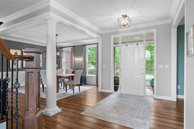foyer with hardwood / wood-style floors, baseboards, a chandelier, decorative columns, and crown molding
