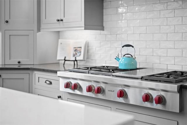 kitchen featuring decorative backsplash, stainless steel gas stovetop, and light countertops