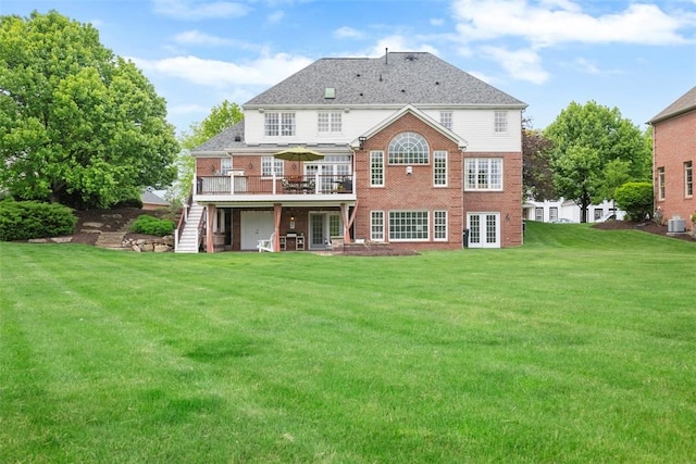 back of property with stairs, a wooden deck, a yard, brick siding, and french doors