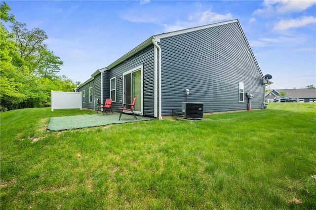 view of side of property featuring a patio area, central AC unit, and a lawn