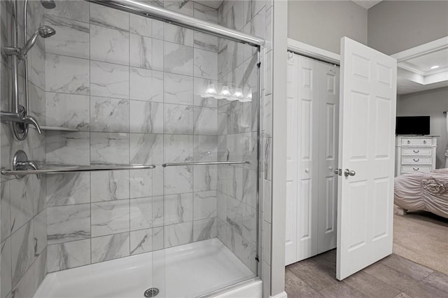 bathroom featuring a shower stall, ensuite bath, and wood finished floors