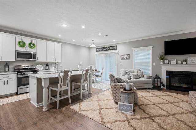 kitchen with stainless steel appliances, recessed lighting, a sink, white cabinets, and crown molding