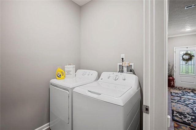 laundry room featuring separate washer and dryer, crown molding, and baseboards