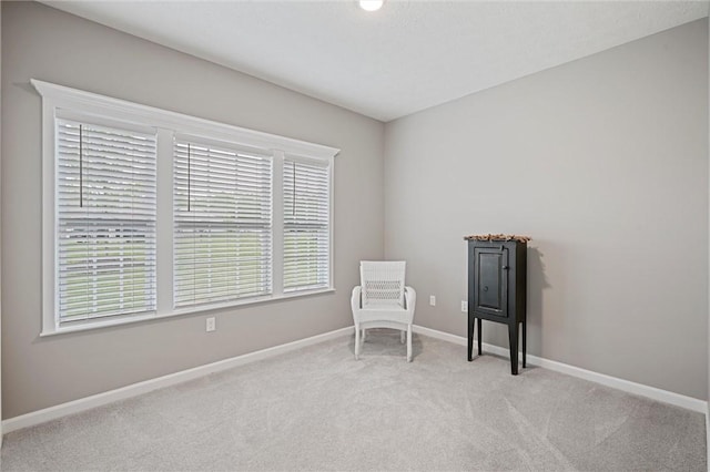 living area featuring carpet flooring and baseboards