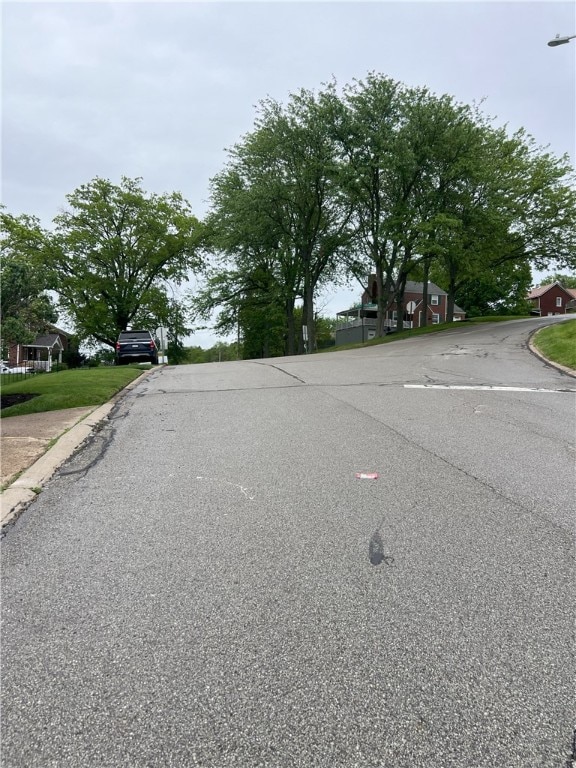 view of asphalt street with curbs