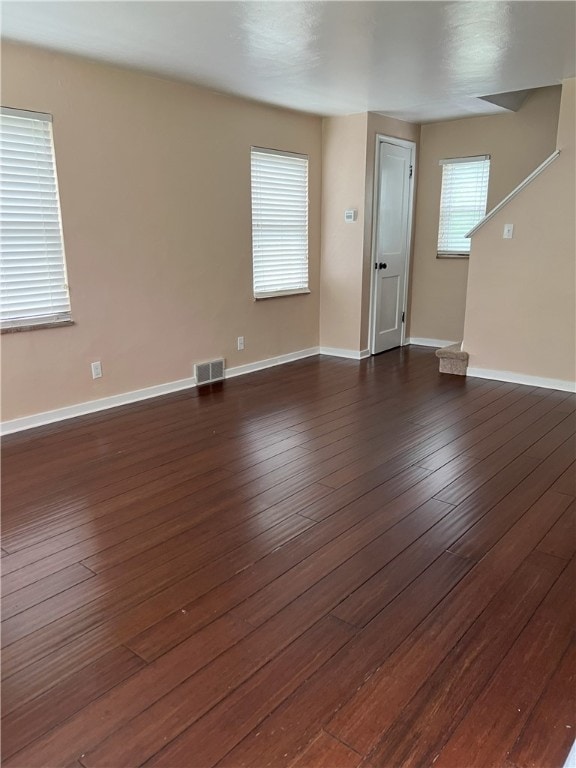 unfurnished living room featuring dark wood-style floors and baseboards