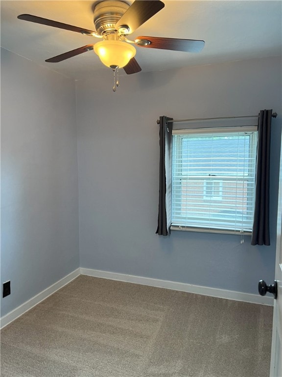 spare room with carpet, baseboards, and ceiling fan