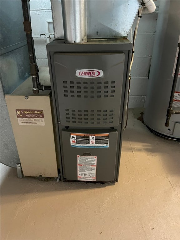 utility room featuring gas water heater and heating unit