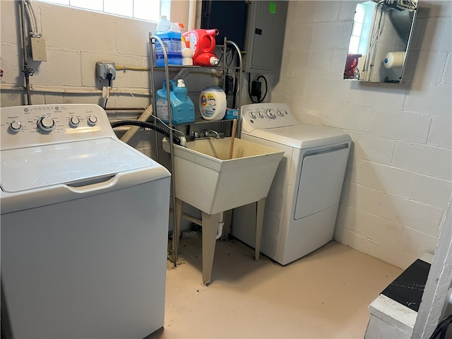 washroom featuring washing machine and dryer and concrete block wall