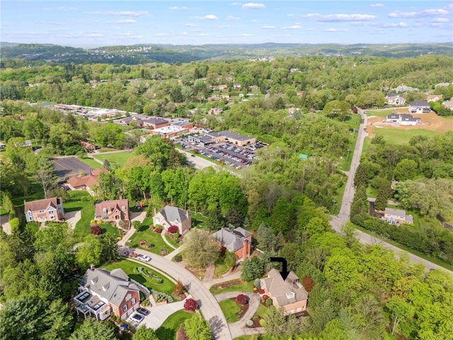 aerial view of property and surrounding area featuring a forest