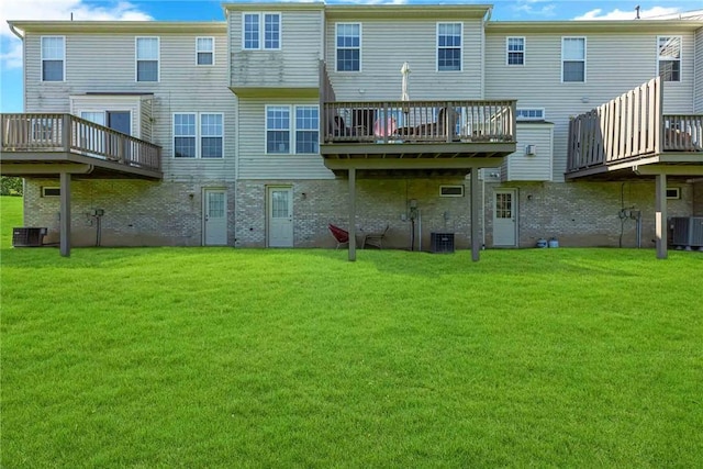 rear view of property with central AC unit, a lawn, and a deck