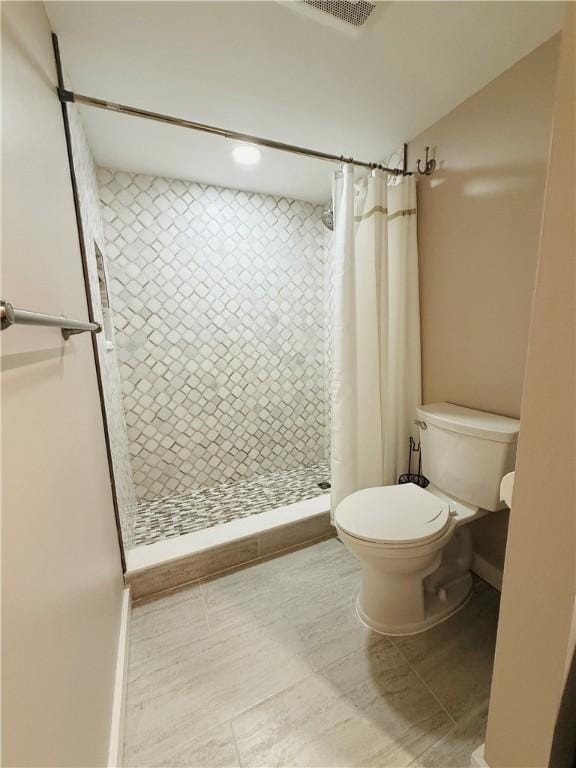 full bath featuring toilet and a shower stall