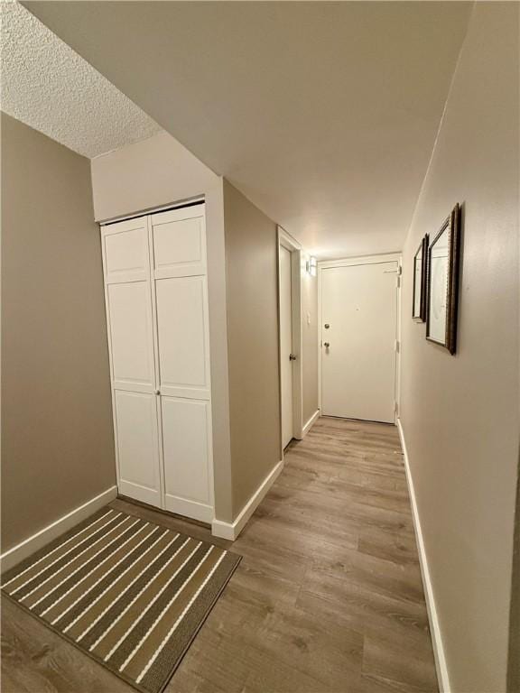 hall featuring baseboards and wood finished floors