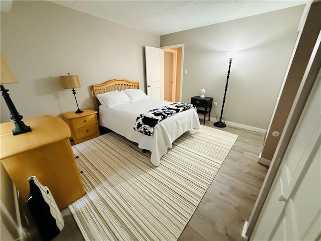 bedroom featuring light wood-style floors and baseboards