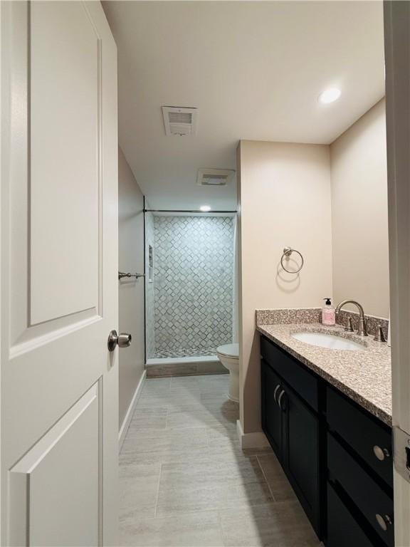 full bath featuring a stall shower, toilet, vanity, baseboards, and recessed lighting