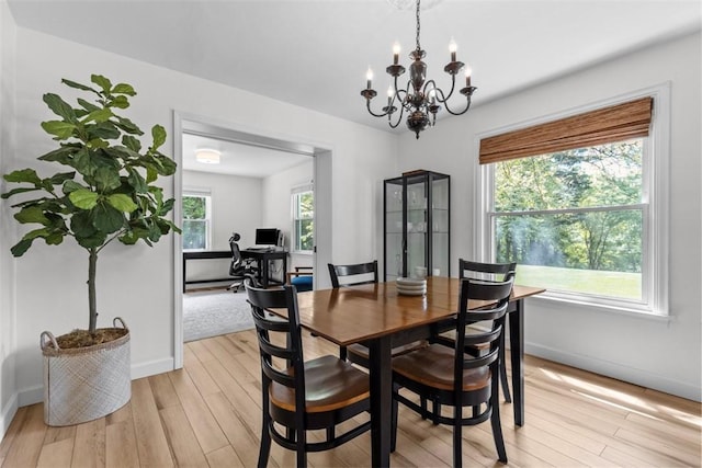dining room featuring a chandelier, light wood-type flooring, baseboards, and a desk