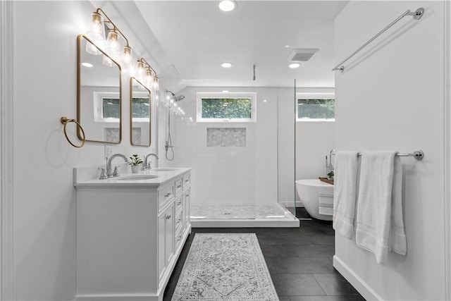 full bathroom with double vanity, tiled shower, a freestanding tub, and recessed lighting