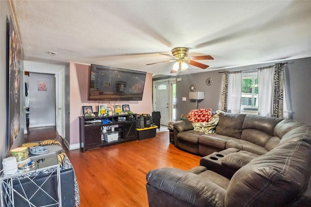 living room with wood finished floors, ceiling fan, and baseboards