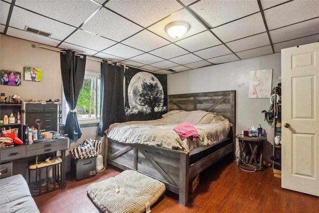 bedroom with wood finished floors and a paneled ceiling