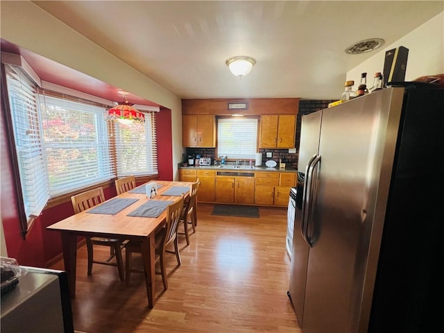 3750 Margate Rd, Churchill Boro, PA 15221 - kitchen featuring stainless steel fridge, brown cabinetry, light wood-type flooring, a sink, and backsplash