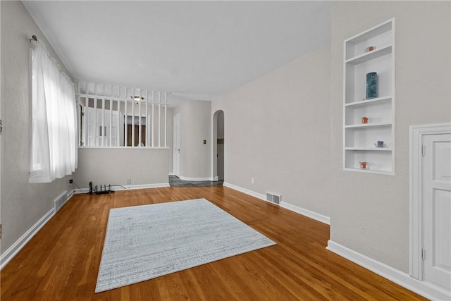 202 Pickwick Dr, Bethel Park, PA 15102 - spare room featuring arched walkways, wood finished floors, built in features, and baseboards