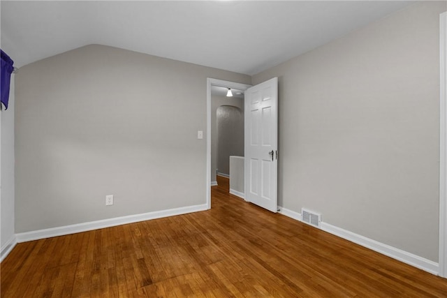 202 Pickwick Dr, Bethel Park, PA 15102 - unfurnished bedroom featuring arched walkways, wood finished floors, baseboards, and lofted ceiling