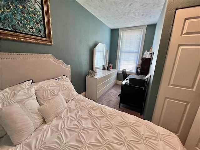 bedroom with a textured ceiling, baseboards, and carpet