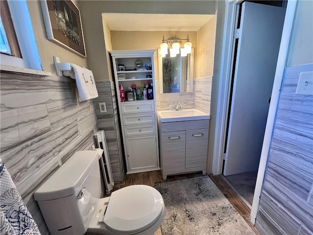 bathroom featuring toilet, wood finished floors, and vanity
