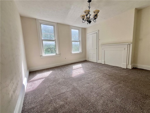 unfurnished dining area featuring a chandelier, carpet flooring, and baseboards