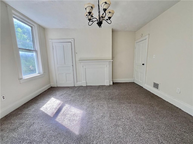 unfurnished dining area featuring a chandelier, carpet flooring, and baseboards