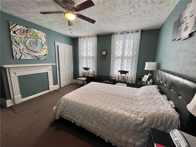 carpeted bedroom with a textured ceiling, a ceiling fan, baseboards, and a fireplace