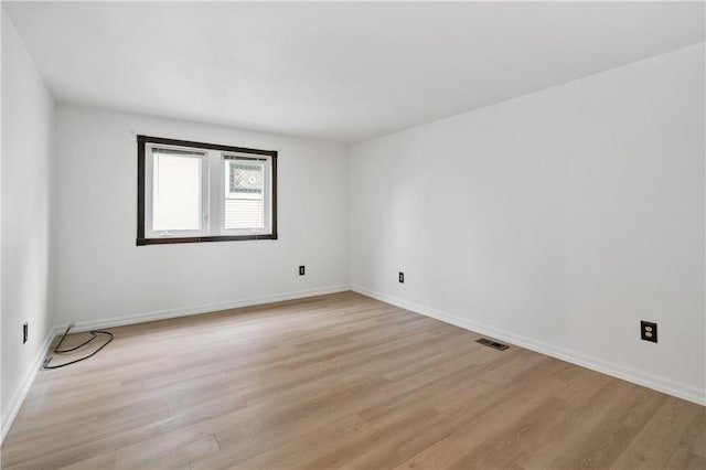 empty room with light wood-style flooring and baseboards