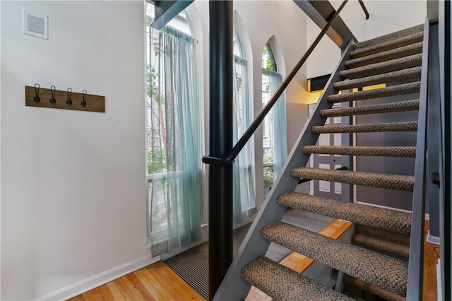 staircase with wood finished floors and baseboards