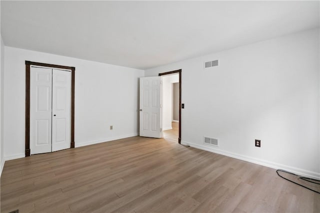 unfurnished bedroom with light wood-type flooring and baseboards