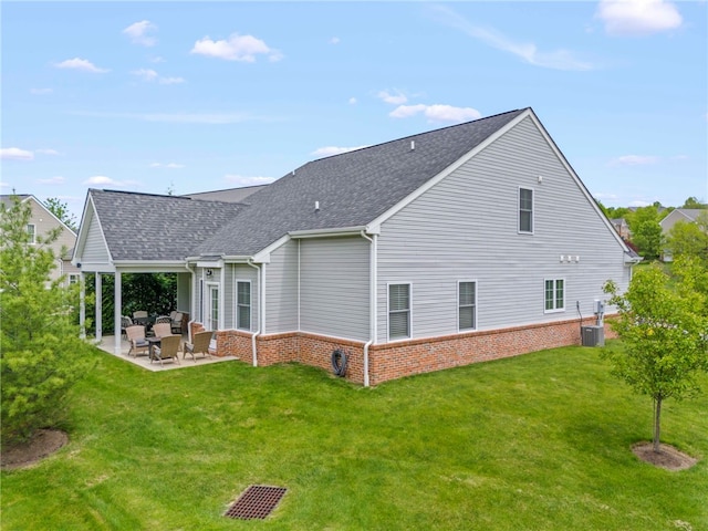 rear view of property with a shingled roof, a lawn, a patio, and central air condition unit