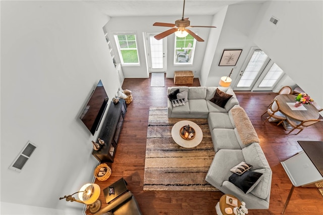 living area featuring vaulted ceiling, ceiling fan, wood finished floors, and baseboards