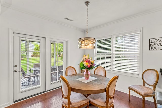 dining area with a chandelier, ornamental molding, dark wood finished floors, and baseboards