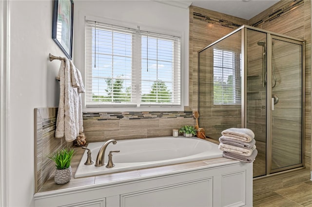 full bathroom with a shower stall, a garden tub, and healthy amount of natural light