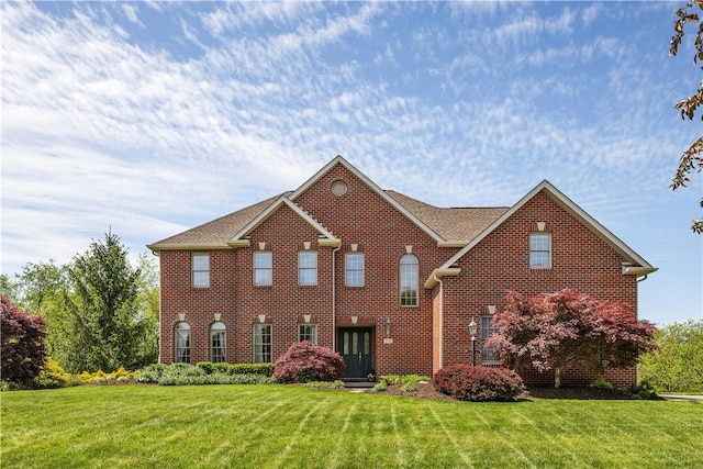 view of front of property with a front yard and brick siding
