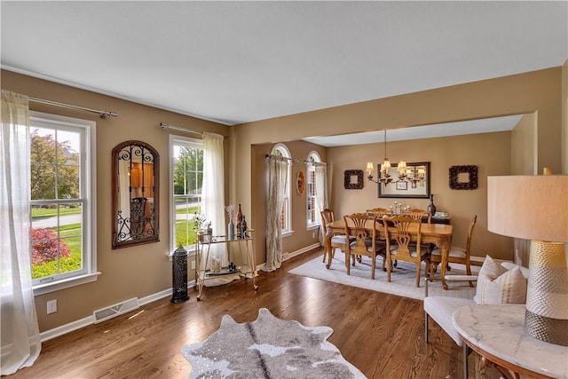 dining room with a chandelier, wood finished floors, and baseboards