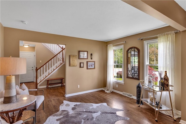 sitting room featuring wood finished floors, stairs, and baseboards
