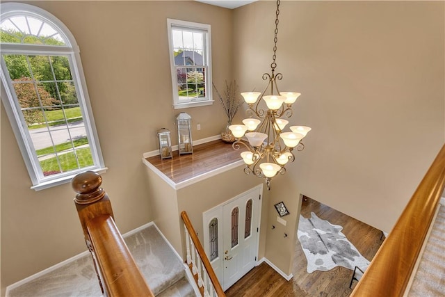 detailed view of a chandelier, baseboards, and wood finished floors