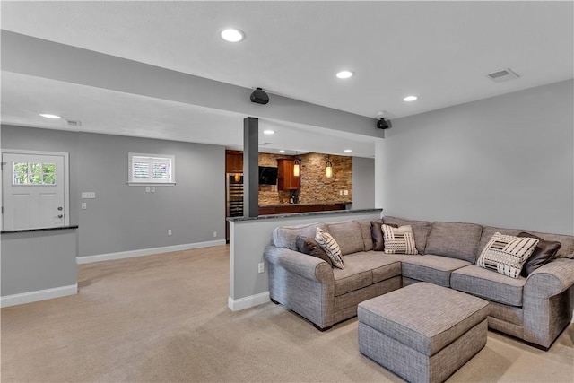 living area featuring light carpet, recessed lighting, baseboards, and bar