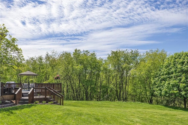 view of green lawn featuring a wooden deck