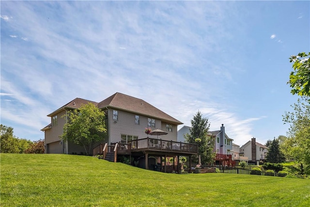 rear view of property with a deck and a garage