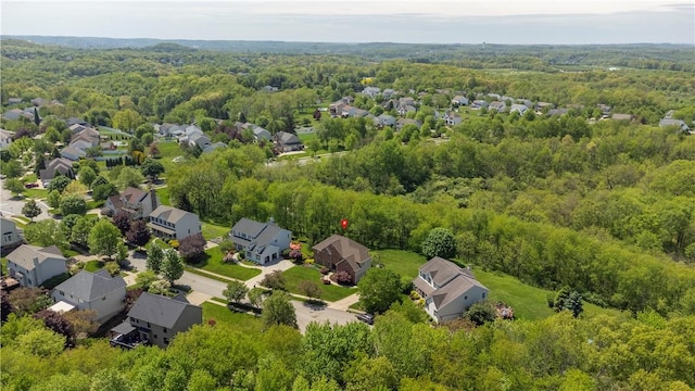 aerial perspective of suburban area featuring a heavily wooded area