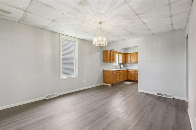 1017 Main St, Coraopolis, PA 15108 - kitchen with dark wood-type flooring, light countertops, a drop ceiling, a chandelier, and baseboards
